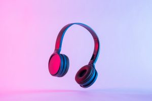 Black headphones floating against a gradient pink and blue background