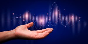 A hand reaching out with sound wave patterns against a blue background