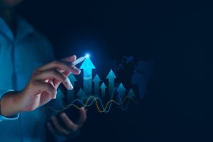 A hand touching a glowing arrow with upward trends on a dark background