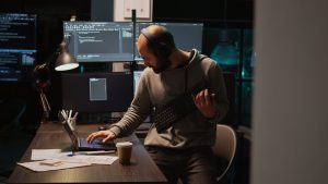 A person with a headset works at a desk with computers and documents